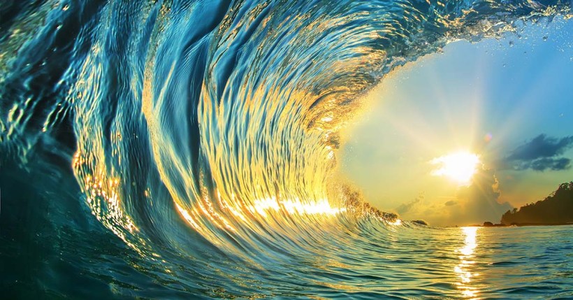 rough colored ocean wave falling down at sunset time